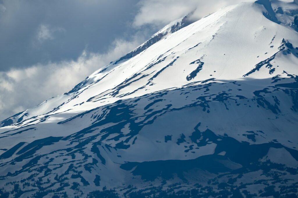 A snow covered mountain under a cloudy sky