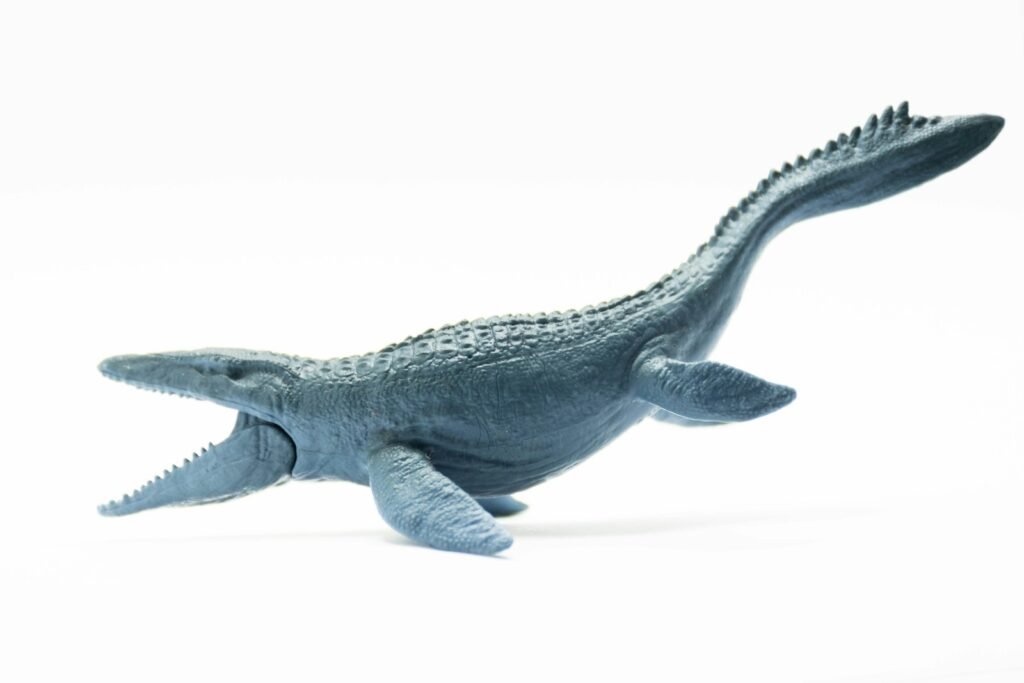 a toy alligator is laying down on a white surface
