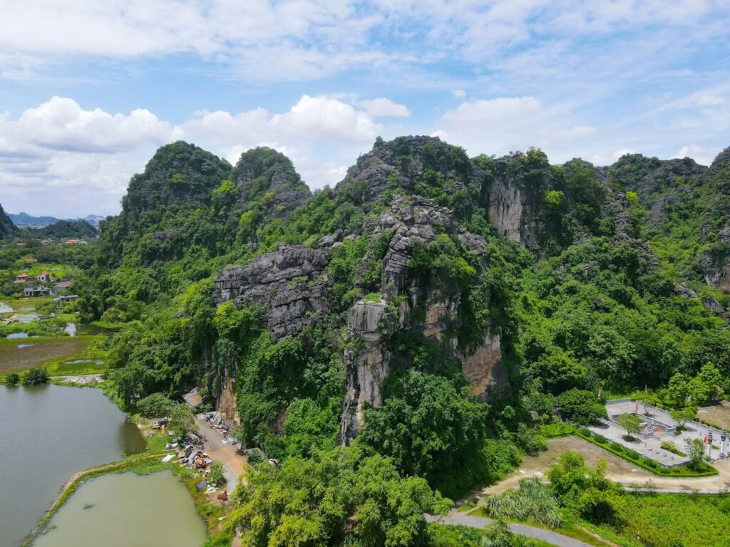 Lush green mountains rise above rice paddies and water.