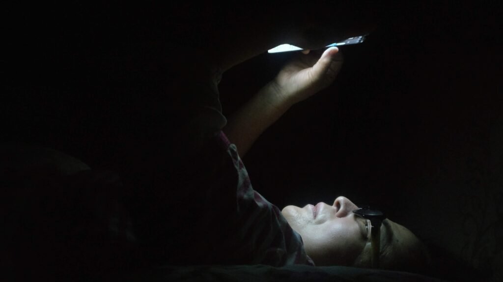 a person laying in the dark with a flashlight in their hand