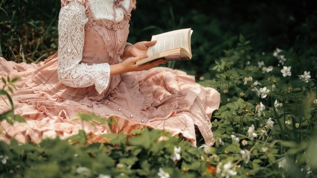 Woman in lace dress reading a book among spring flowers in a forest meadow.