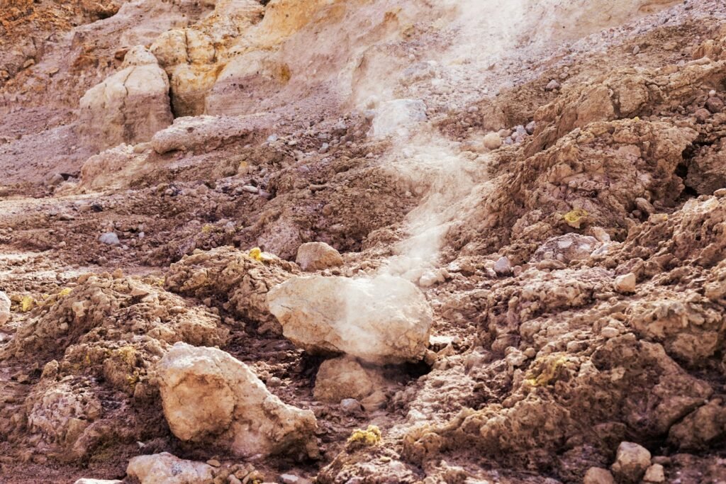 a rocky area with a white substance coming out of the ground