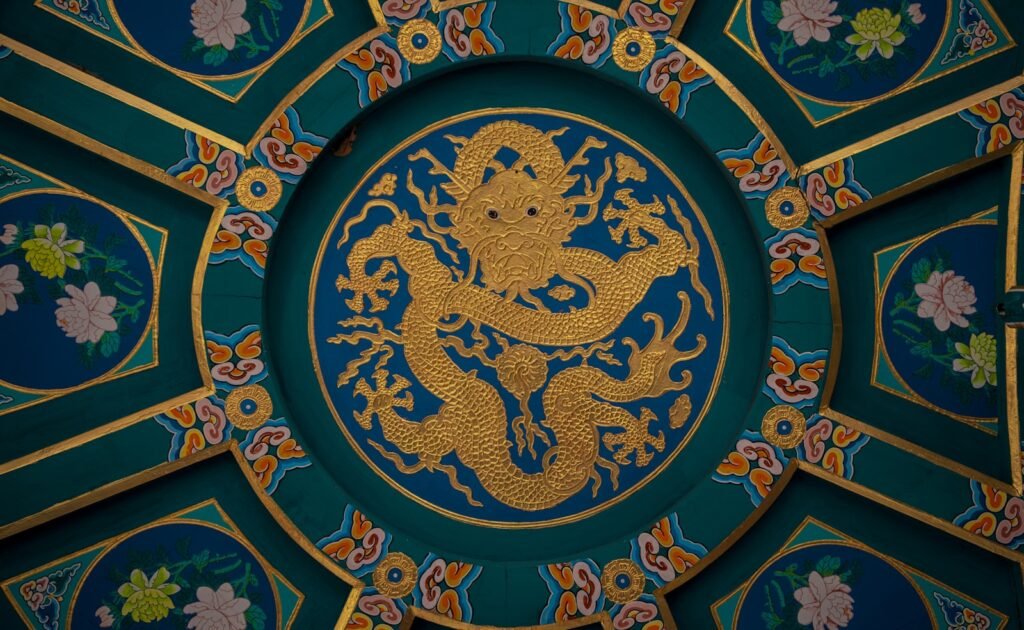 A golden dragon is centered in an ornate ceiling.