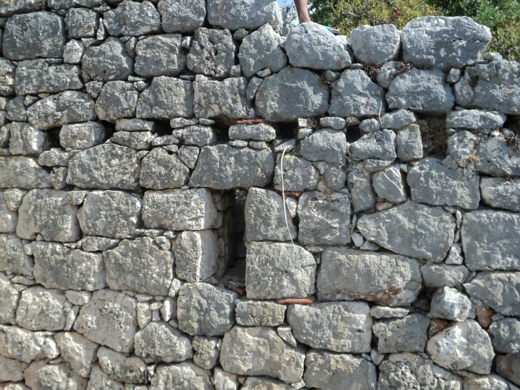 a stone wall with a small window in it