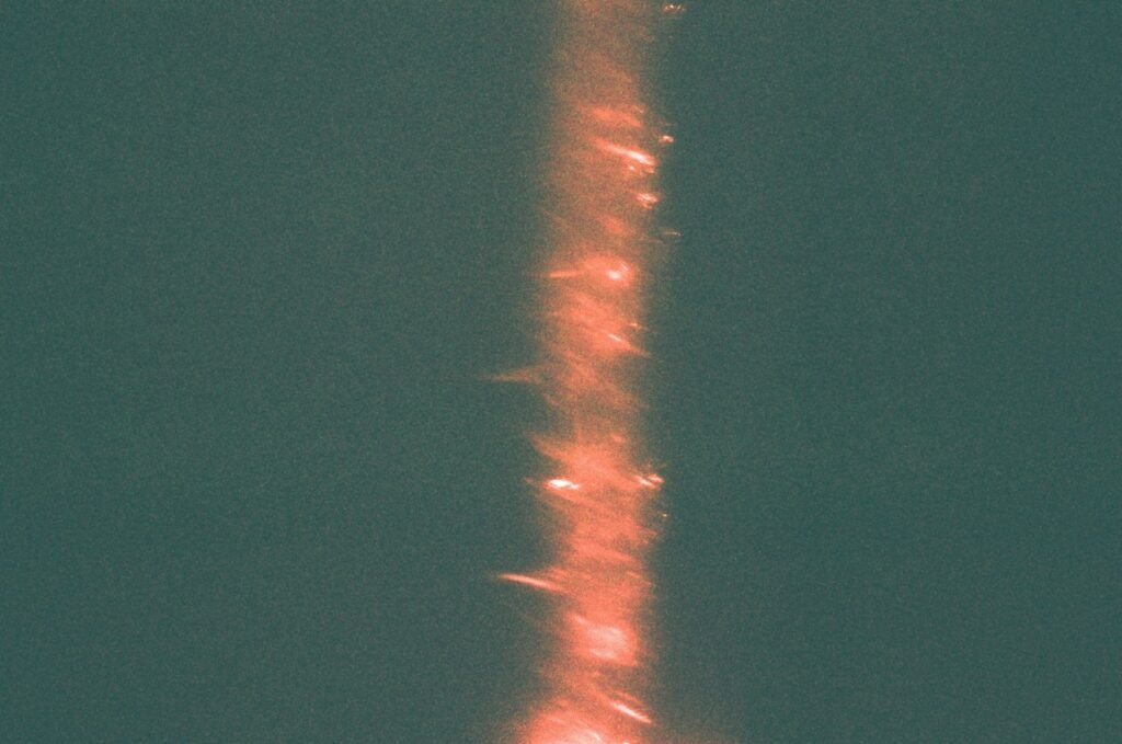 Vertical streak of orange sparks against dark background