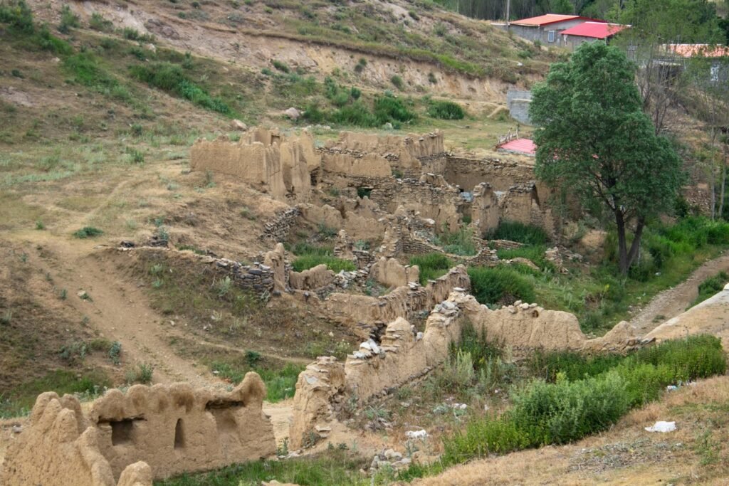 Ancient ruins of mud brick structures on a hillside.