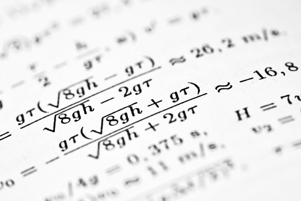 Mathematical formulas are written on a white sheet of paper.