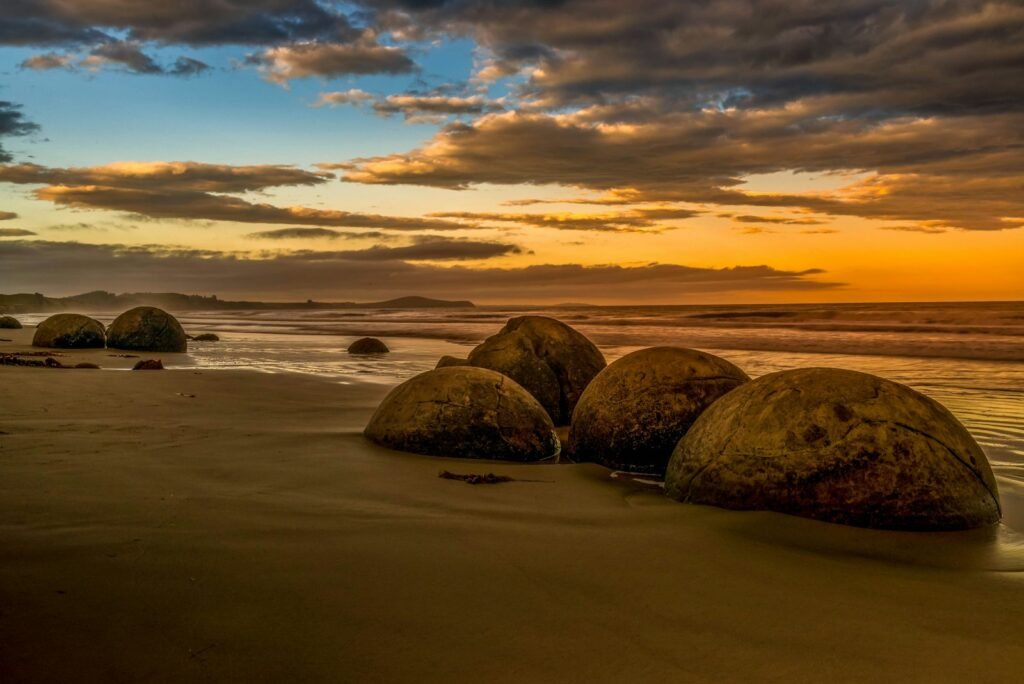 brown rocks on beach during sunset