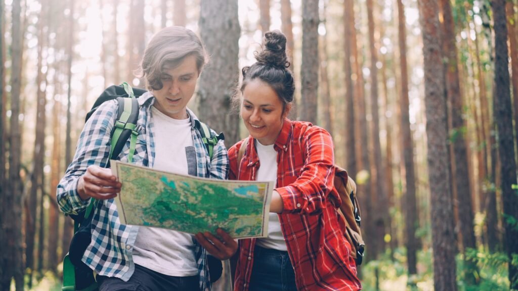 Two hikers looking at a map in a forest